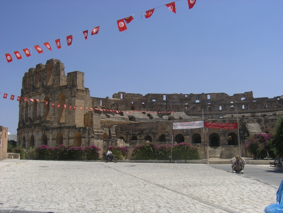 Vue de l’extérieur du grand amphithéâtre d’El-Jem, dans son environnement urbain moderne.