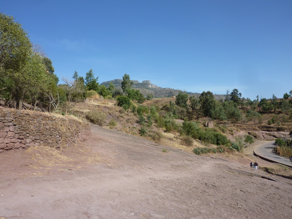 Vue du Mont Ašatan en arrière-plan, contraste entre le basalte scoriacé au premier plan (roche rouge) au niveau de Lalibela et l’ignimbrite qui ressort en blanc sur les hauteurs du mont Ašatan.